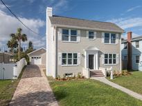 Charming two-story home with a brick driveway, white shutters with palm trees, and a detached garage at 727 N Grandview Ave, Daytona Beach, FL 32118