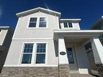 Charming two-story home featuring stone accents, light-colored stucco and decorative shingles, and a welcoming front porch at 5318 Center Lake Ranch Blvd, Saint Cloud, FL 34771