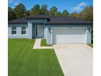 Charming single-story home boasts a manicured lawn and attached two-car garage at 13739 Sw 43Rd Cir, Ocala, FL 34473