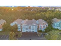 Condominium complex with colorful exteriors nestled among lush trees in a serene, suburban setting at 12843 Madison Pointe Cir # 107, Orlando, FL 32821