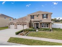 Two-story house with three-car garage, landscaped yard, and stone accents at 1316 Fountain Hills Ct, Winter Park, FL 32792