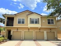 Multi-Gathering home featuring garages and a second-story balcony under a partly cloudy sky at 2856 Oakwater Dr # 2856, Kissimmee, FL 34747
