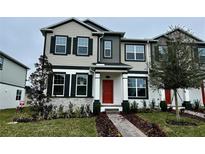 Two-story home with red door and landscaped yard at 783 Pilea St, Apopka, FL 32703