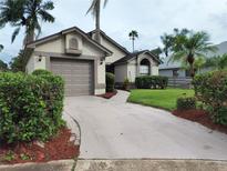 Charming single-Gathering home featuring a well-manicured lawn, mature landscaping, and an attached garage at 2168 Meadow Ct, Apopka, FL 32703