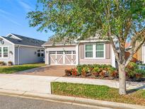 Charming single-story home featuring a brick driveway, lovely landscaping and a two-car garage at 349 Alcove Dr, Groveland, FL 34736