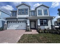 Beautiful two-story home featuring a two-car garage and a charming brick walkway at 5069 Rain Shadow Dr, Saint Cloud, FL 34772