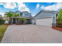 Beautiful two-story home featuring a three-car garage, brick paved driveway and lush landscaping at 7508 Lake Albert Dr, Windermere, FL 34786