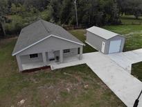 Inviting single-story home featuring a metal garage, well-manicured lawn, and a cozy front porch at 9650 Nw Gainesville Rd, Ocala, FL 34475