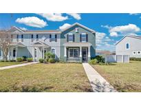 Charming two-story townhome with a well-manicured lawn and inviting front porch, perfect for enjoying the outdoors at 514 Rainbow Springs Loop, Groveland, FL 34736