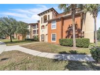 Building exterior featuring Spanish-style architecture, landscaping, and a walkway at 5512 Metrowest Blvd # 110, Orlando, FL 32811