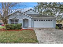 One-story house with a two-car garage and well-maintained landscaping at 6621 Bouganvillea Crescent Dr, Orlando, FL 32809