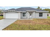 Newly constructed one-story home with gray exterior, white garage door, and stone accents at 258 Fraser Rd, Debary, FL 32713