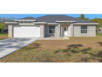 Newly constructed home with gray exterior, white garage door, and stone accents at 258 Fraser Rd, Debary, FL 32713