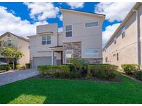 Modern two-story home with stone accents and landscaped yard at 8956 Hilton Ridge Ave, Kissimmee, FL 34747