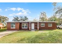 Front view of charming ranch house with green lawn at 2313 Savoy Dr, Orlando, FL 32808