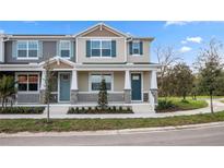 Charming townhome with a welcoming porch, blue door, decorative shutters, and manicured landscaping at 1267 Tarflower Dr, Winter Springs, FL 32708