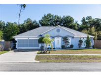 Charming single-story home showcasing a light blue exterior, well-manicured landscaping, and a two-car garage at 1269 Buccaneer Ave, Deltona, FL 32725
