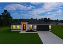 Charming single-story home featuring a well-manicured lawn and a modern garage door at 6421 Sw 151St Loop, Ocala, FL 34473