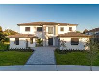 Two-story home with gray stone and white siding, paver driveway, and landscaping at 5762 Emerington Cres, Orlando, FL 32819