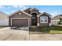 Two-story house with a two-car garage and landscaped lawn at 326 Highland Meadows Ave, Davenport, FL 33837