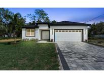 Charming single-story home featuring a clean design, large driveway, and manicured lawn at 205 E 17Th St, Apopka, FL 32703