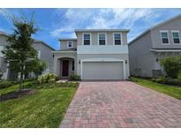 Charming two-story home featuring a brick driveway, an attached two car garage and well-maintained landscaping at 1162 Happy Forest Loop, Deland, FL 32720