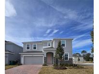 Two-story house with gray siding, two-car garage, and landscaping at 1200 Bear Oak Ln, Deland, FL 32720