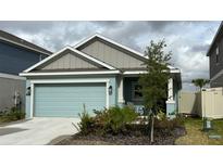 Single-story home with light teal garage door and landscaping at 207 Aqua Ave, Davenport, FL 33837