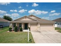 Charming single-story home featuring a three-car garage, well-maintained lawn, and a cozy front porch at 236 Barrington Dr, Haines City, FL 33844