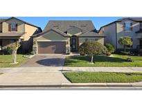 Charming single-story home with a manicured lawn and a brick paved driveway leading to a two-car garage at 2532 Civitas Pl, Casselberry, FL 32707