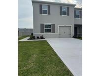 Two-story home featuring gray siding, neat landscaping, a one-car garage, and gray shutters at 3337 Private Oak Dr, Apopka, FL 32703
