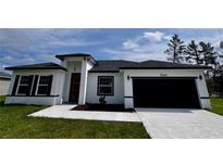 Charming single-story home with a white exterior, dark roof, and well-manicured lawn at 3041 Sw 168Th Loop, Ocala, FL 34473