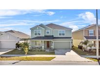 Charming two-story home featuring a covered front porch, attached two-car garage and landscaped yard at 871 Fillmore Ct, Davenport, FL 33837