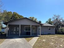 Charming single-story home with a covered front porch and well-maintained landscaping at 1111 South St, Eustis, FL 32726