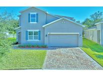 Charming two-story home with a brick driveway and manicured lawn and blue shutters at 3207 Stratton Cir, Kissimmee, FL 34744