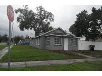 Charming gray home with a well-maintained lawn and a stop sign nearby on an overcast day at 1600 Roosevelt Ave, Orlando, FL 32804