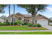 Beautiful single-story home with lush landscaping, mature trees, and inviting curb appeal at 807 Grovesmere Loop, Ocoee, FL 34761