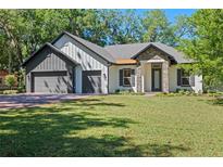 Charming single-story home with stone accents, three-car garage, and a well-manicured lawn at 347 Mission Rd, Oviedo, FL 32765