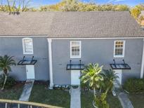 Gray two-story townhouses with dark gray roofs, and covered entrances at 4408 Sun Village Blvd, Kissimmee, FL 34746