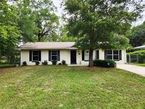 Charming single-story home featuring a well-maintained lawn and mature shade tree at 849 Orange Oak Dr, Orange City, FL 32763