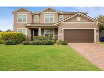 Two-story house with brown garage door and manicured lawn at 752 Sandy Bar Dr, Winter Garden, FL 34787