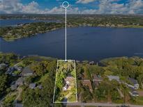 Expansive aerial view of a lakeside home showcasing lush landscaping and scenic water views at 1003 Oakdale St, Windermere, FL 34786