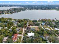 Stunning aerial view of lakefront home highlighting property lines and the beautiful surrounding landscape at 1003 Oakdale St, Windermere, FL 34786