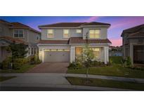Charming two-story home features a well-maintained lawn, tiled roof, and attached two car garage at 13333 Oakenshaw Ln, Orlando, FL 32832