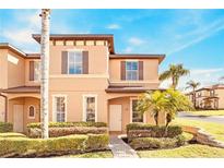 Two-story townhome with attractive landscaping and a paved walkway at 100 Palermo St, Davenport, FL 33897