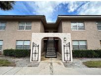 Inviting two-story condo featuring a staircase leading to the second floor and well-maintained landscaping at 1171 Calle Del Rey # D, Casselberry, FL 32707