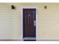 A brown front door with a door knocker in a light yellow building at 411 Lucaya Loop # 411, Davenport, FL 33897