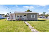 Charming single-story home featuring a covered porch, white picket fence, and a well-maintained front yard at 710 Spruce St, New Smyrna Beach, FL 32168