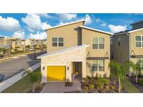 Two-story house with yellow garage door and landscaped yard at 571 Drop Shot Dr, Davenport, FL 33896