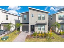 Two-story modern home with gray siding, landscaped yard, and paved walkway at 1179 Kingsbarn St, Davenport, FL 33896